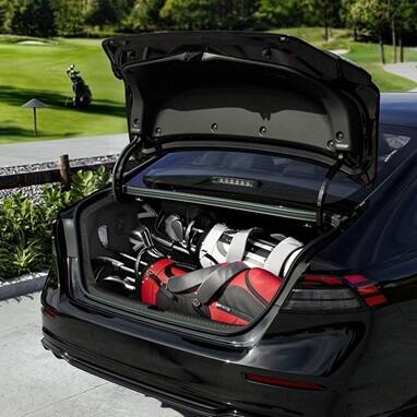 2026 Honda Accord in Crystal Black Pearl rear view parked at a golf course, with the self-opening trunk popped open with golf bags in the trunk.