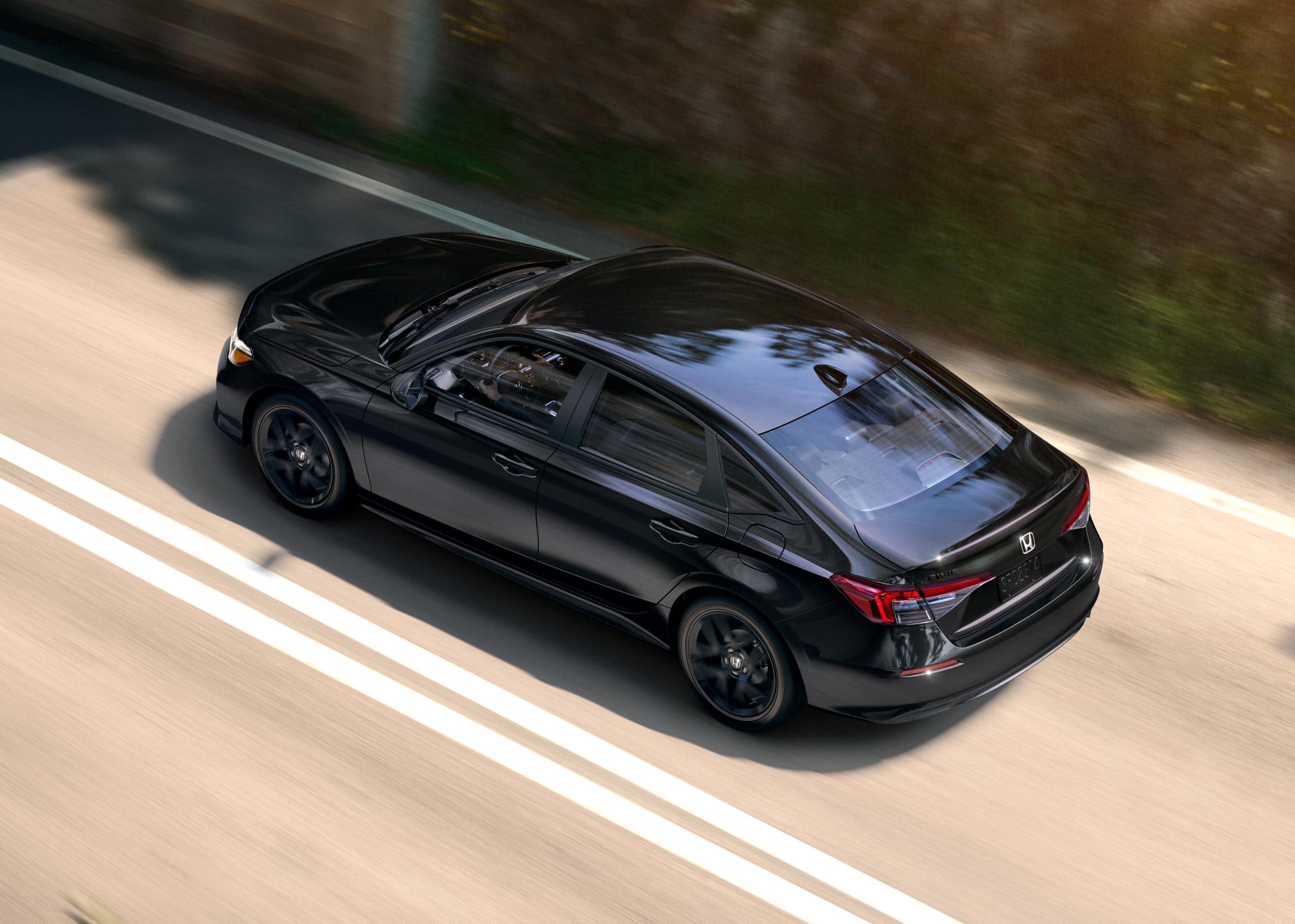 2026 Honda Civic Sedan Sport in Crystal Black Pearl high-angle rear three-quarter view driving on a road (Compact Sedan)